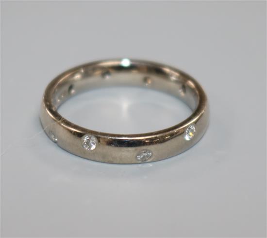 A modern 18ct white gold and gypsy set diamond band, size I.